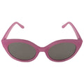 A pair of pink cat-eye sunglasses rests facing forward with dark lenses reflecting light creating a stylish accessory suitable for sunny outdoor settings.