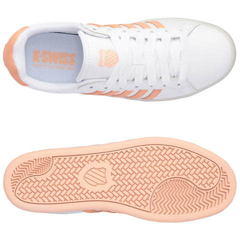 White sneakers with peach accents are presented from a top view alongside the sole. The shoes feature laces and branding on the insole, showcasing a sporty aesthetic.