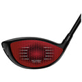 A black golf driver with a red honeycomb-patterned face is positioned at an angle showcasing its technological features and design elements aimed at enhancing performance on the golf course