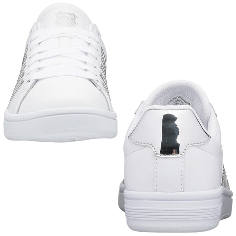 White sneakers featuring a smooth leather exterior and a reflective heel accent are positioned side by side against a neutral background, highlighting their simple yet modern design.