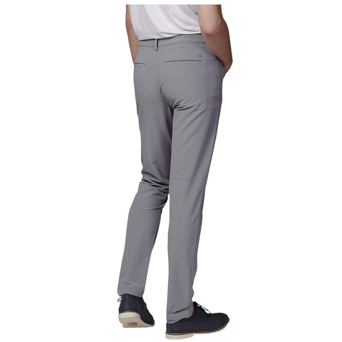 Gray pants are worn by a person facing away with hands in pockets on a plain background, highlighting the sleek design and fit of the garment.