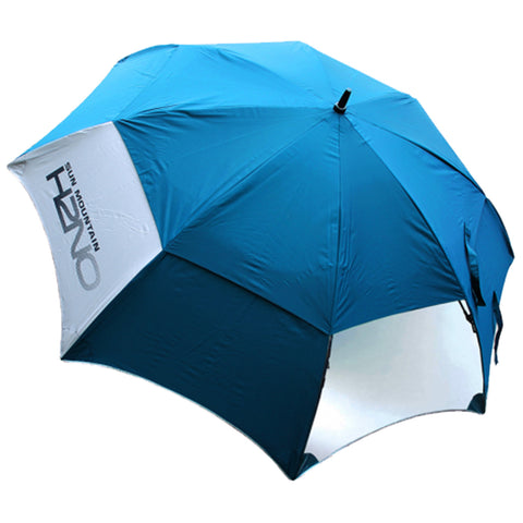 A large blue umbrella is positioned upright providing shade it features a white section with branding and is designed for use in sunny outdoor environments such as beaches or gardens