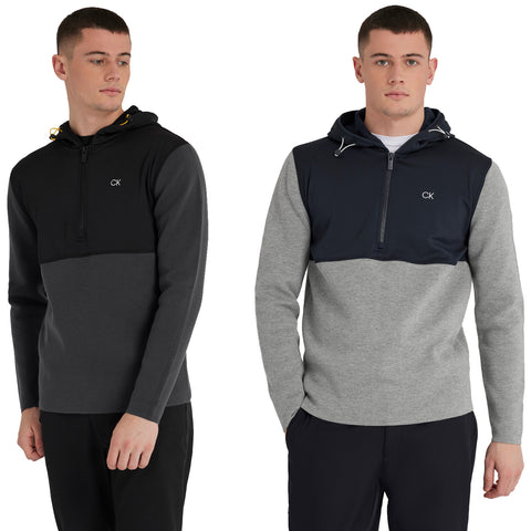 Two young men are standing side by side wearing hooded sweatshirts in contrasting colors with logos visible. The first features black and gray panels while the second displays shades of gray and navy.