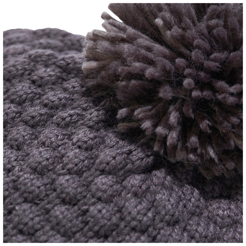 A knitted gray hat with a fluffy pom-pom is displayed closely showing its textured surface and soft material providing a warm and cozy appearance.