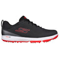 A black athletic shoe with textured upper and red accents is displayed. It is designed for sports activities with a white sole featuring protruding spikes for traction on grassy surfaces.