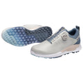 A pair of golf shoes features a light gray upper with a blue accent around the collar and a BOA lacing system the sole has a textured grip with a blue gradient