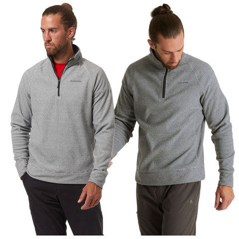 A man wearing a grey pullover with a half-zip stands in two poses looking serious in a neutral setting showcasing the garment's texture and design features.