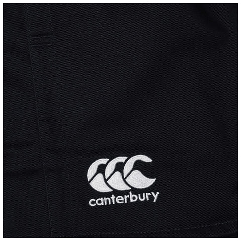 A black fabric displays a white embroidered logo featuring three stylized waves and the word canterbury below it representing a sportswear brand in a casual setting.