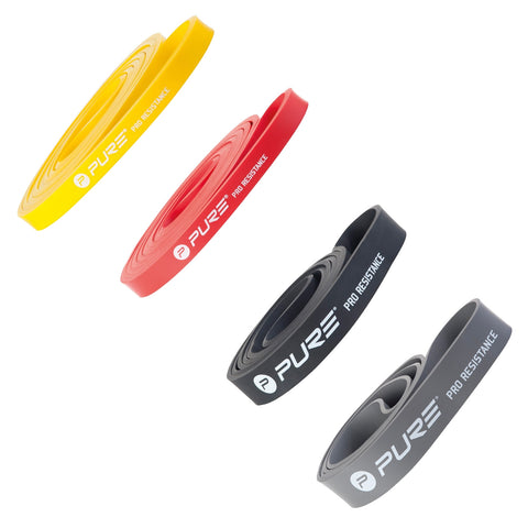 Four resistance bands lie flat with varied colors: yellow, red, and two shades of gray. They feature branding with the word "PURE" and are designed for strength training.