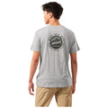 A young man stands with his back to the viewer wearing a gray t-shirt featuring a circular graphic with the text "NEVER HOLD BACK ALWAYS MOVE AHEAD EXPLORER CLUB BASE CAMP" above a mountain design.