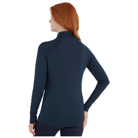 A woman with reddish hair is wearing a fitted, dark long-sleeve top she stands with her back turned facing slightly left in a plain white background