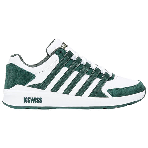 A white and dark green athletic shoe is displayed upright showing its side profile featuring multiple green stripes and a textured finish along with the brand name on the heel.