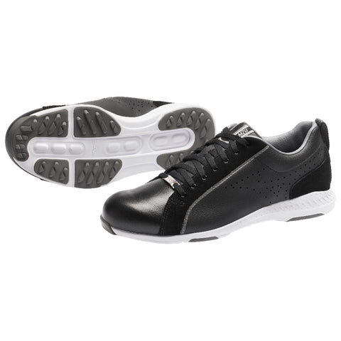 Black athletic shoes are positioned with a white sole and grey accents showcasing a sleek design and textured surface placed on a neutral background highlighting their sporty appearance.