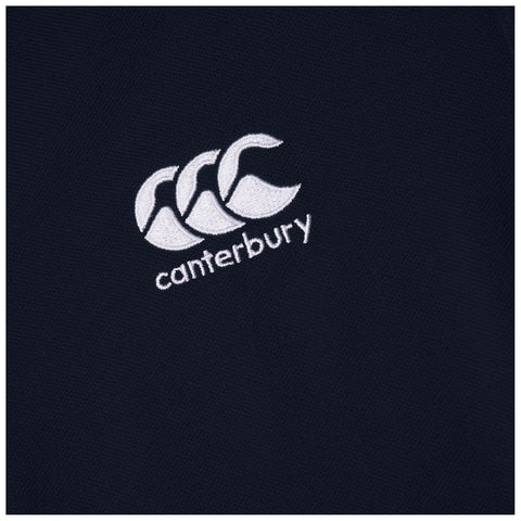 A black textile features an embroidered logo depicting three stylized waves above the word canterbury, conveying a sense of athletic branding and teamwork often associated with sports apparel.