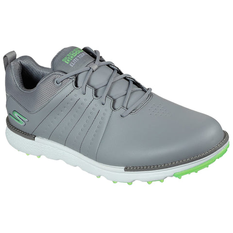 A gray golf shoe features a sleek design with textured material and green accents positioned on a white outer sole with small spikes suitable for grip on grass surfaces.