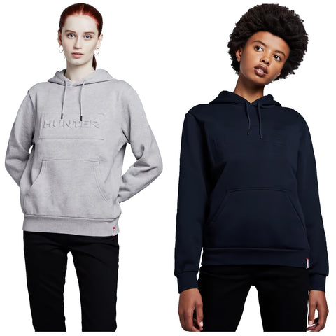 Two individuals are wearing hooded sweatshirts one in light gray and the other in dark navy both featuring a front pocket and a logo embossed on the chest in a neutral background.