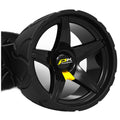 A black golf trolley wheel with a sporty design spins smoothly on a surface showcasing a prominent logo in yellow and black emphasizing its brand identity.