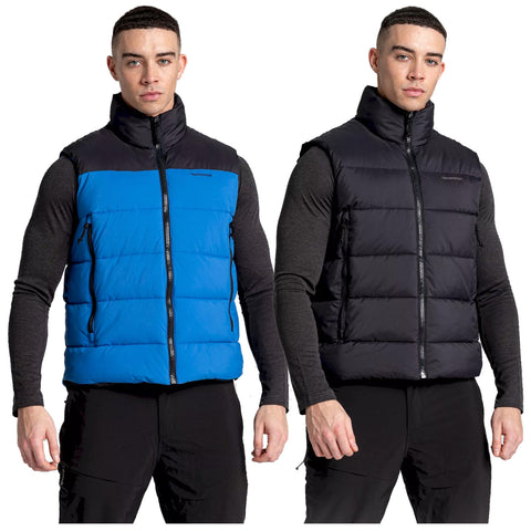 A man poses wearing two distinct puffer vests one blue and one black showcasing the vests' quilted texture and high collars against a plain background highlighting the garments.