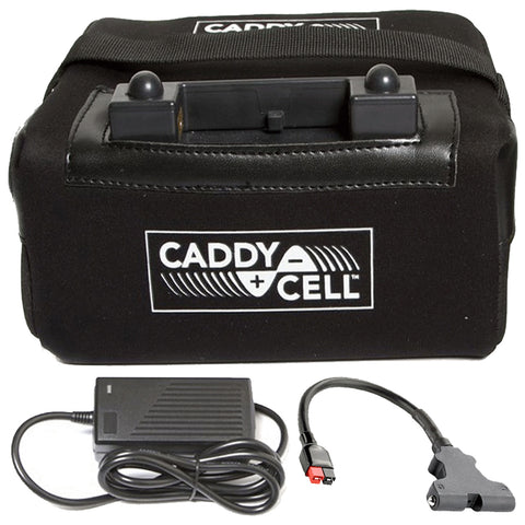 A black rectangular bag with a logo labeled CADDY + CELL contains a battery compartment on top along with an external power adapter and a connector cable placed in front on a flat surface.