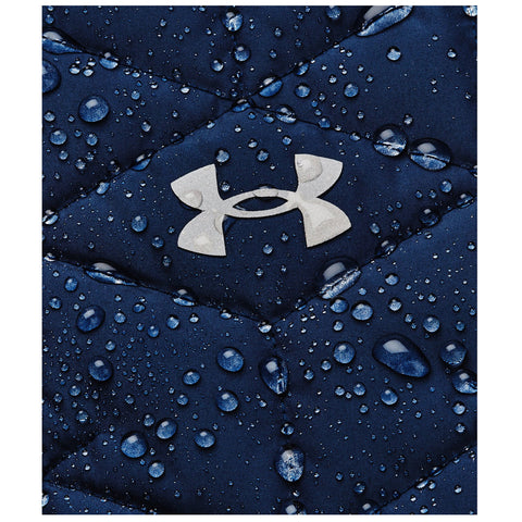 A dark blue quilted fabric is featured with numerous droplets of water on its surface. A silver logo is prominently displayed in the center, indicating a sports brand.