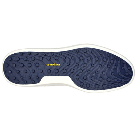 A shoe sole features a textured pattern with circular indentations for traction displaying the word GOODYEAR in yellow against a dark blue background with a white edge surrounding it.