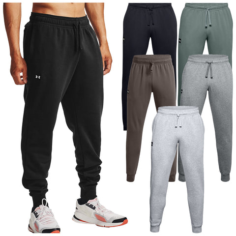 Men's black sweatpants are being worn by a person standing with hands on hips displaying various other color sweatpants including navy green brown and grey in a display context.