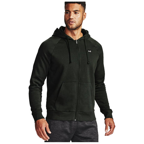 A man wearing a dark green zip-up hoodie stands confidently with his arms relaxed at his sides in a neutral background showcasing the hoodie’s casual design and athletic fit.