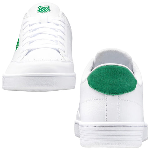 White sneakers with green accents are positioned side by side displaying a smooth finish and laced fronts while surrounded by a neutral background emphasizing their clean design and casual style.