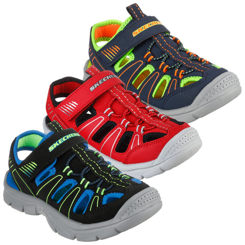 Three pairs of colorful children’s sandals are displayed side by side featuring red black and blue styles The sandals have open designs with straps and are suitable for casual wear