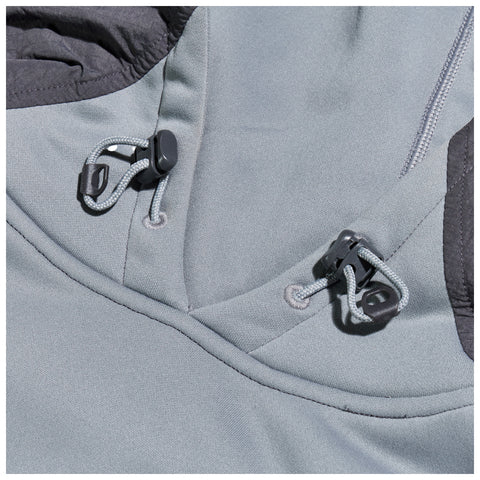 A gray fabric section features two black toggles and elastic cords The toggles secure the cords in place as part of a clothing design emphasizing function and fit