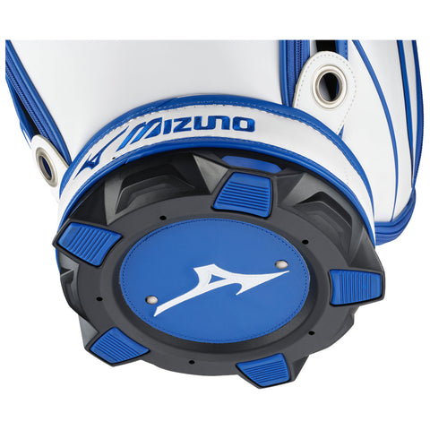 A golf bag base features a circular blue backing with black rubber grips and a white logo prominently displayed at the center positioned on a white and blue-accented bag.