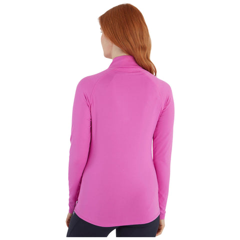 A woman is wearing a long-sleeve, pink athletic shirt which has a high collar. She is standing with her back to the viewer in a neutral, unobtrusive background.